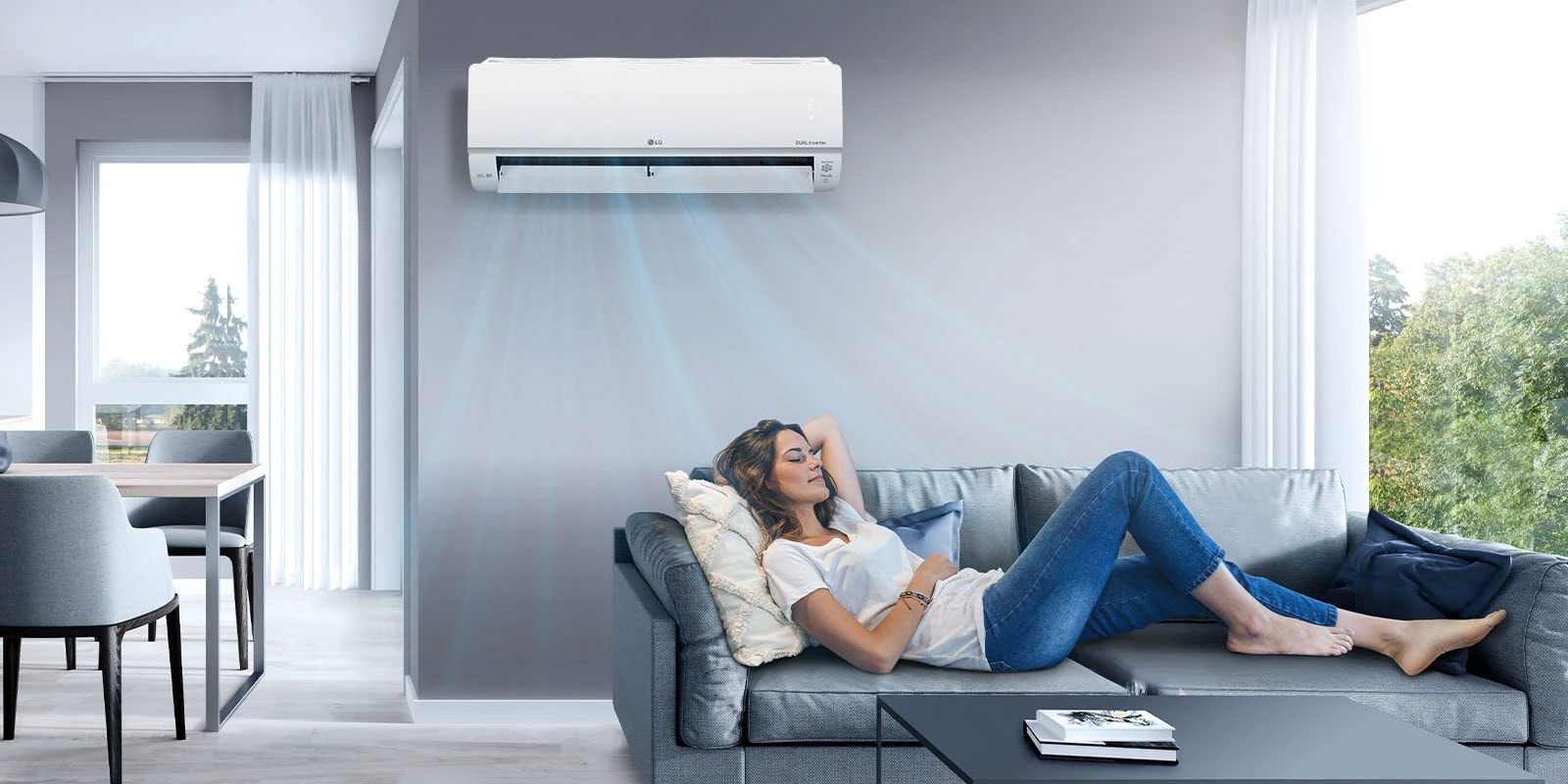 A woman lounges on a couch in a living room with the LG air conditioner installed above her on the wall. Blue streams of air are on the image to indicate it is on and cooling the room.