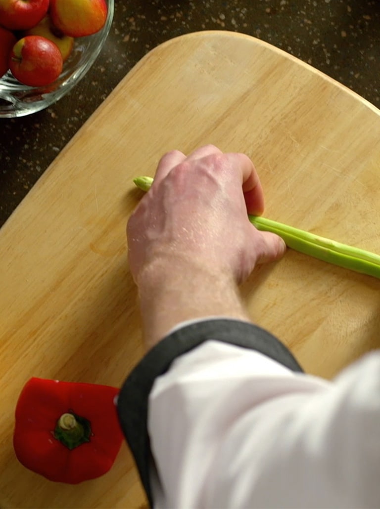 The chef is trimming the ingredients.