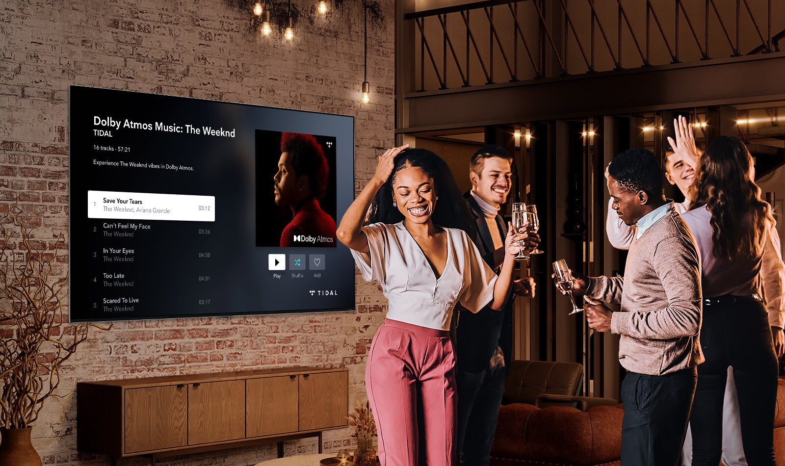 Four people dancing and enjoying drinks at a house party while music is playing on a large, wall-mounted LG QNED Mini LED TV.