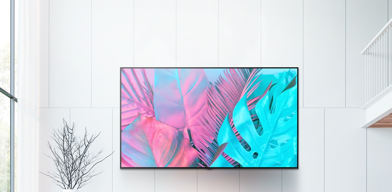 A large flatscreen TV mounted against a white wall. The screen shows large leaves in bright colors.